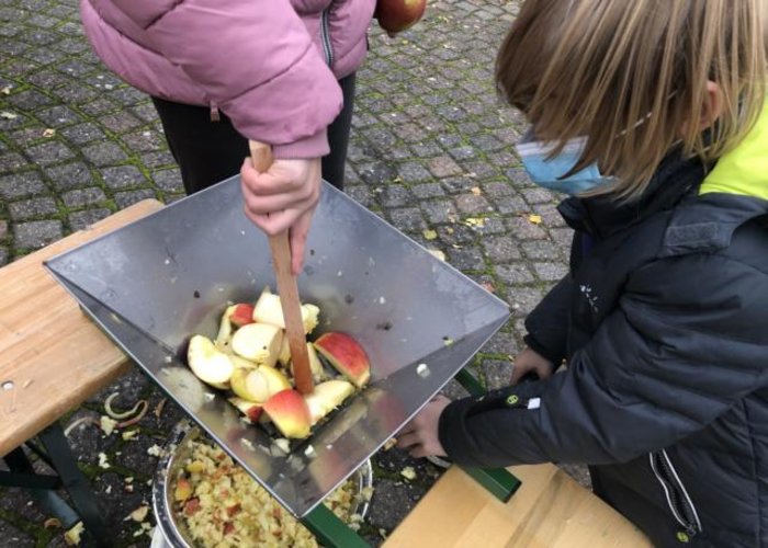 Die Kindergruppe macht Apfelsaft